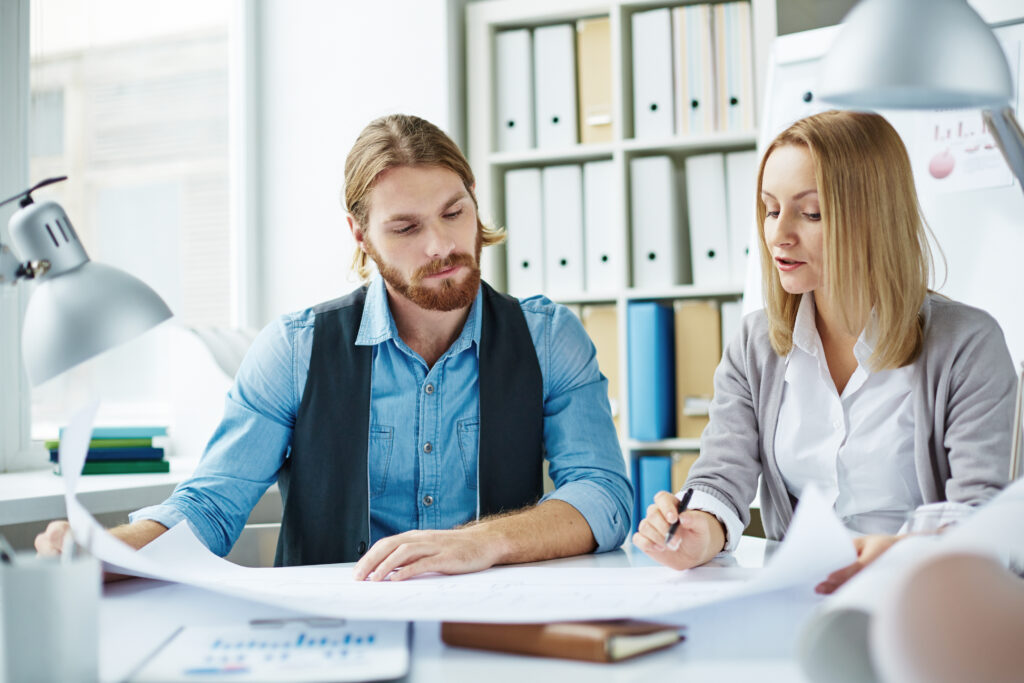 business colleagues at a desk writing a plan together