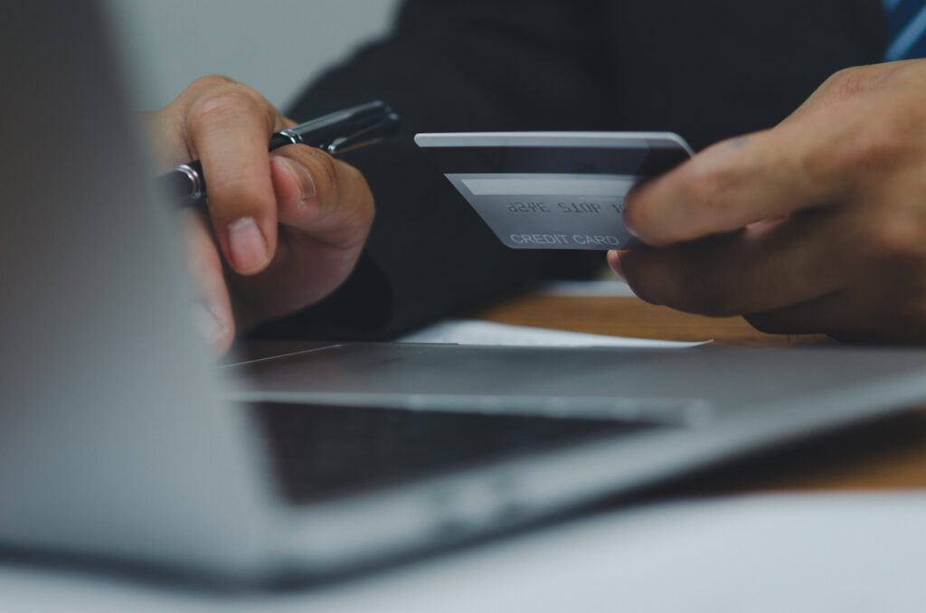 man putting card details into computer