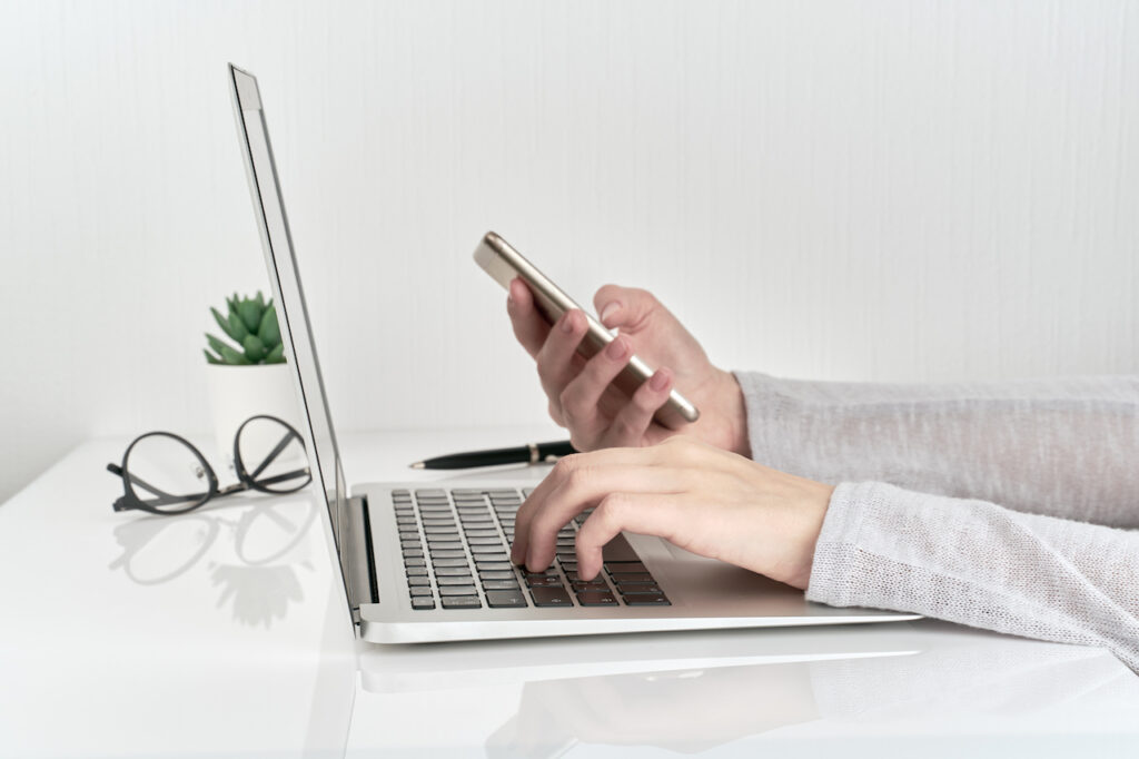 woman typing password into laptop