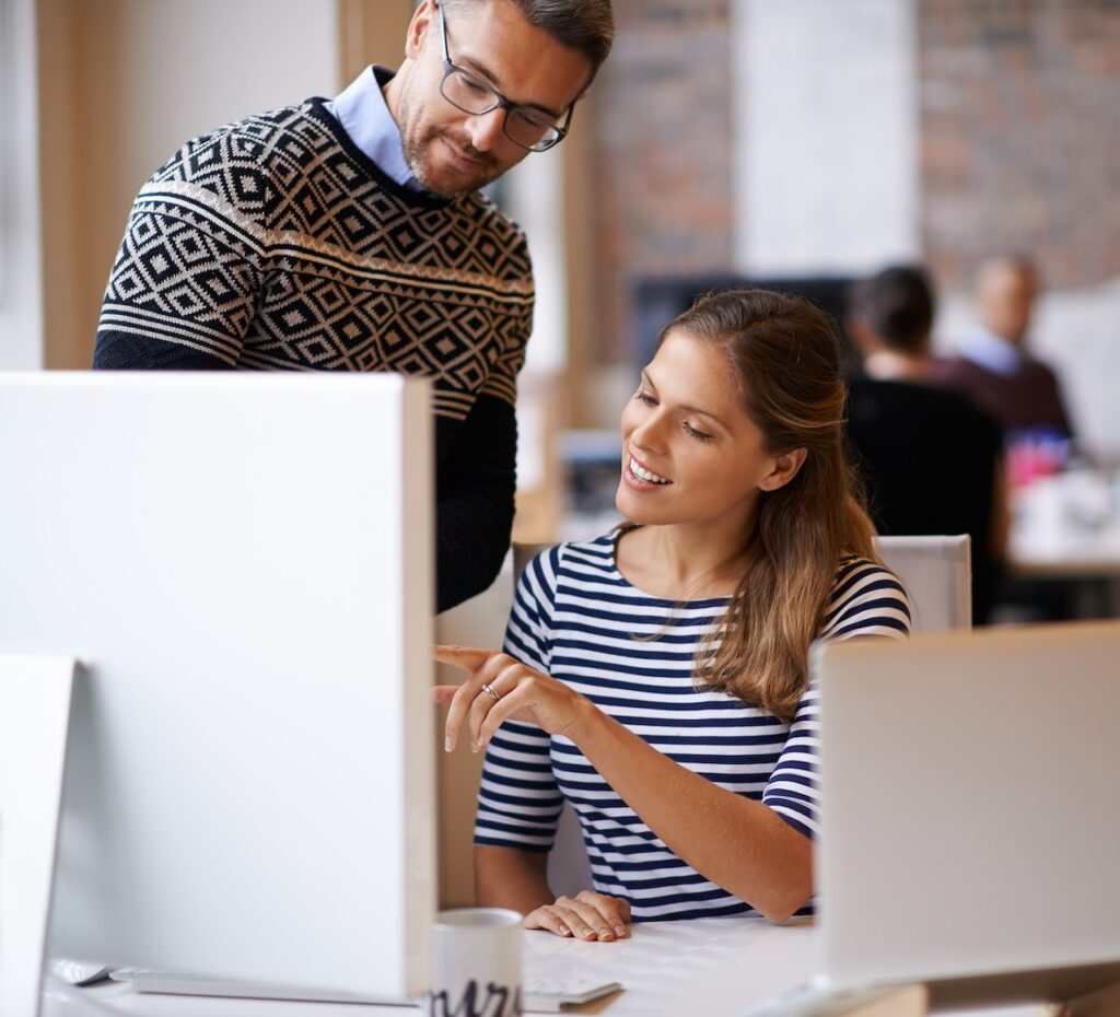 coworkers working on computer at office